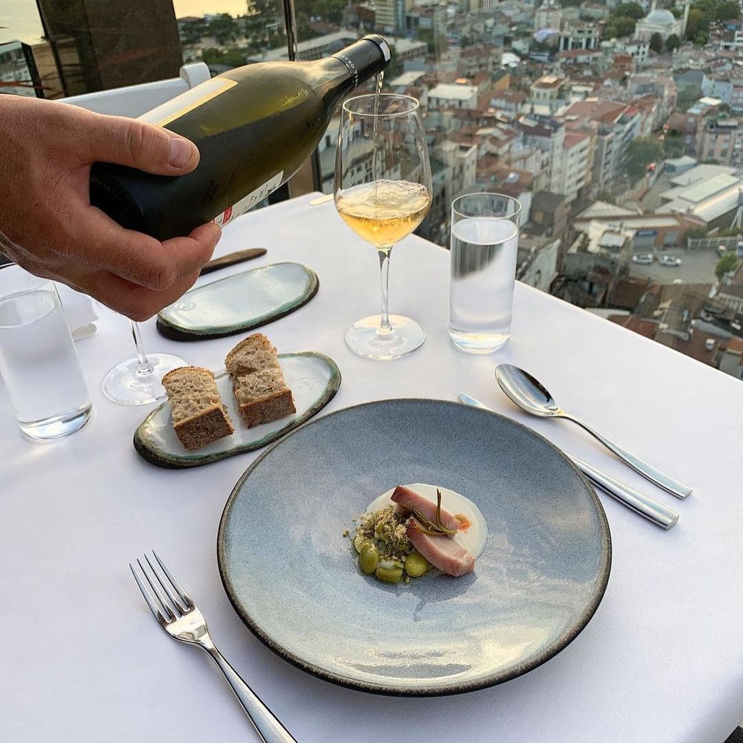 A meal on the table next to window with city view.