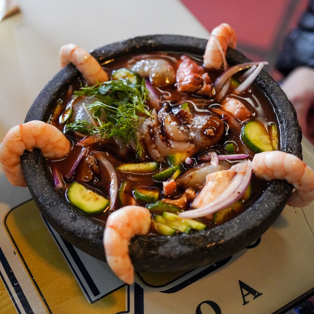 Ceviche Tripón with assorted seafood and serrano juice served in a molcajete